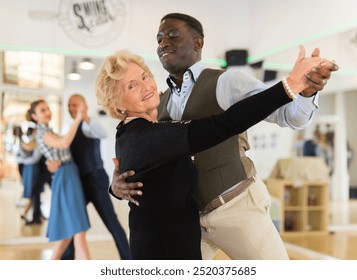 Man and elderly woman performing ballroom dance - Powered by Shutterstock