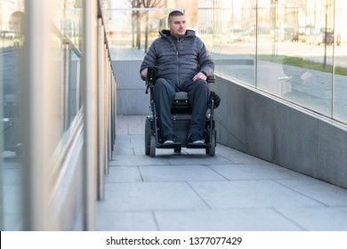Man in a electric wheelchair using a ramp