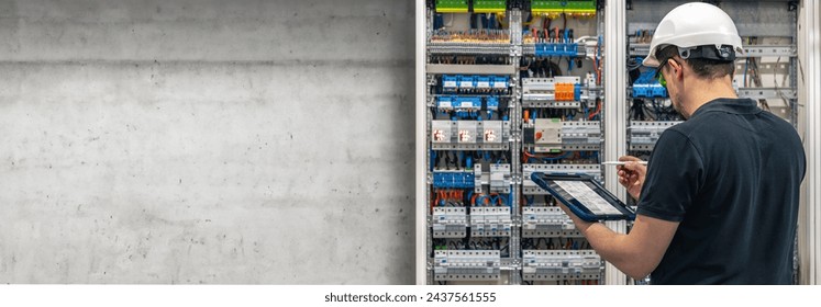 Man, an electrical technician working in a switchboard with fuses.