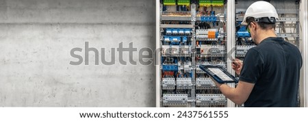 Man, an electrical technician working in a switchboard with fuses.