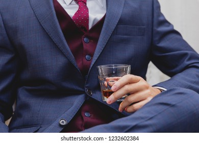 Man In Elegant Suit Holding Glass With Alcohol Drink