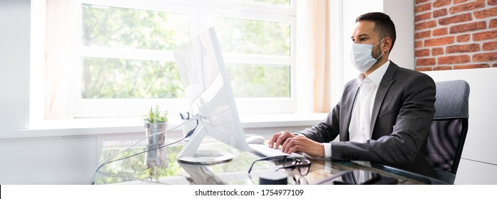 Man Employee In Office Wearing Face Mask Working On Computer
