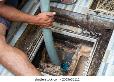 Man Emptying household septic tank. Cleaning and unblocking clogged drain at home.
