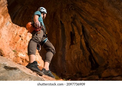 A Man Is Engaged In Rock Climbing, Stands Against The Background Of A Beautiful Red Cave Before Training, The Climber Leads An Active Lifestyle And Is Involved In Extreme Sports In Greece, Twin Caves.