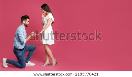 Man with engagement ring making marriage proposal to girlfriend on pink background, space for text. Banner design Foto stock © 