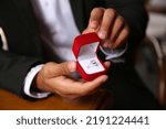 Man with engagement ring making proposal at table, closeup