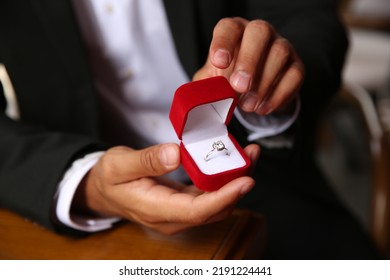 Man with engagement ring making proposal at table, closeup