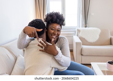 Man with engagement ring proposing marriage to girlfriend in new house, they are kissing with smile. Amazed African American couple getting engaged. She said yes! - Powered by Shutterstock