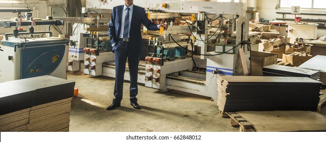 man engineer stand near saw machine to make furniture at carpenters workshop. Handmade business at small furniture factory. man working with robot machine inside workshop - Powered by Shutterstock