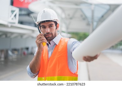Man engineer standing on construction site. construction manager using walkie talkie. Engineer working on outdoor project and talking on phone