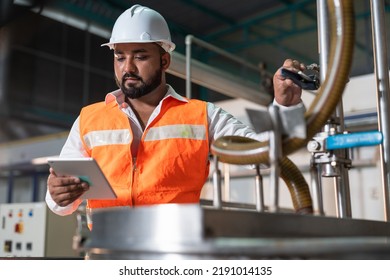 Man Engineer Wear Safety Vest With Helmet Safety Protection Holding Tablet Checking And Repairing Pipe Boiler Pressure Machine In Food And Beverage Factory Industry