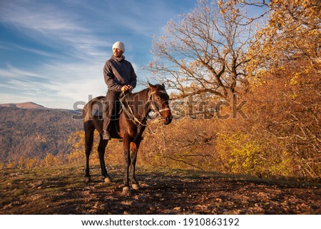 Man enjoy horse. Beautiful autumn landscape. Portrait in nature mountains. People and animals couple. Sport hobby in lifestyle. Horse ride inspiring background. 
