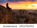 Man enjoying the Beautiful American Mountain Landscape. Dramatic Colorful Sunset Sky Art Render. Taken in Smith Rock, Redmond, Oregon, America. Concept: Adventure, Holiday and Travel