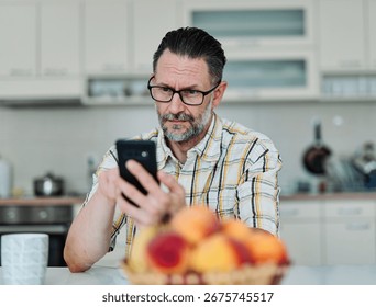 Man enjoying breakfast while using smartphone in modern kitchen during morning hours - Powered by Shutterstock - Get 15% off with code: PIKWIZARD15