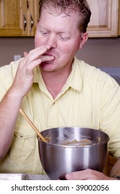 A Man Enjoying And Licking His Fingers After Eating Cookie Dough.