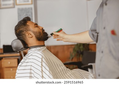 A man is enjoying a meticulous beard trim at a barber shop that provides professional grooming care