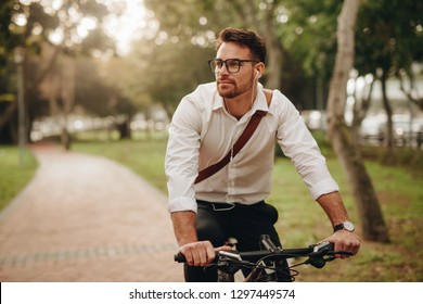 Man enjoying music using earphones while commuting to office bicycle  Businessman biking to office while listening to music 