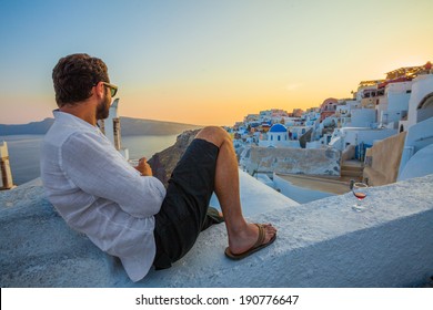 Man Enjoying Wine At Santorini Sunset