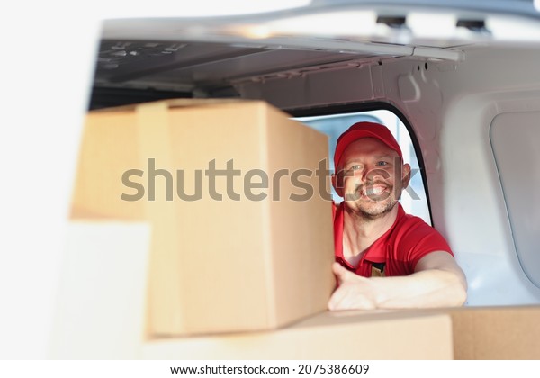 Man enjoying work putting boxes in truck for\
further delivery on address