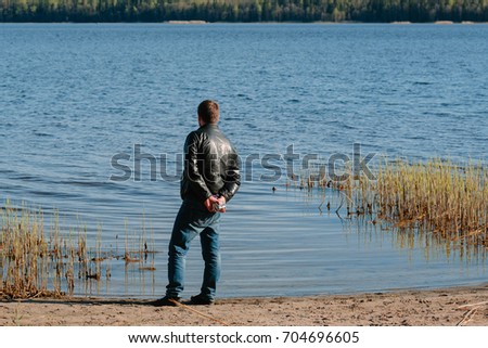 Similar – Man sitting by the river in fall