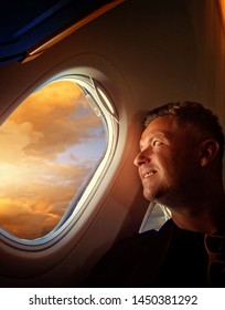 Man Enjoys Traveling By Plane Looking Out The Window