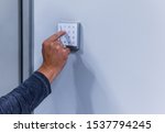 Man entering numeric sequence into keypad used for accessing a secured area
