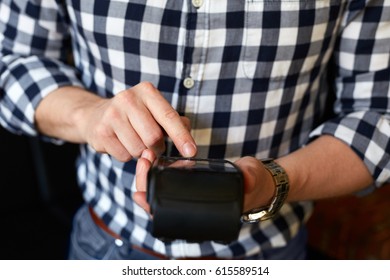 Man Entering PIN Number Using Payment Terminal