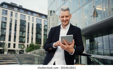 A man of European appearance writes down the task plans in a tablet. A confident freelance manager. An adult gray-haired student does a task online for a new course lesson.