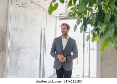 Man european satisfied smiling happy businessman male client 20s wear grey suit enter office business centre looking aside in dealership salon store office indoors Business lifestyle sales concept. - Shutterstock ID 2176112183