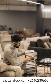 A man evaluates fabric samples while seated in a cozy modern furniture showroom. The environment emphasizes comfort and stylish decor, with neutral tones, showcasing a range of home design 