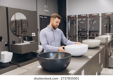 Man examining different options of ceramic washbasins, making a choice for bathroom remodeling and home improvement project