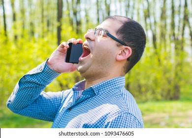 Man Excitedly Talking On The Phone Outdoors