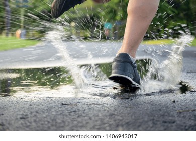 Man exercise running through puddle splashing his shoes.