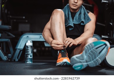 Man exercise workout in gym fitness breaking and resting after training sport with dumbbells and water bottle healthy lifestyle bodybuilding. - Powered by Shutterstock