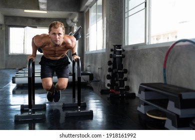 Man Exercising In The Sport Gym. Man Doing Push-ups With Bars In Gym