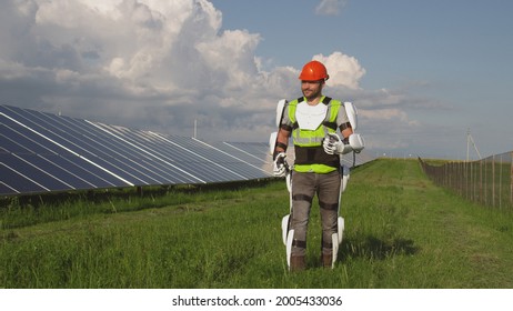 Man In Exoskeleton Walking In Field Near Solar Panels