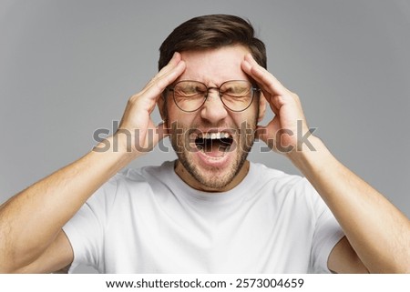 Man experiencing intense stress while holding his head in frustration during a challenging situation