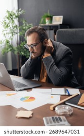 Man experiencing neck pain while working long hours at a corporate office desk