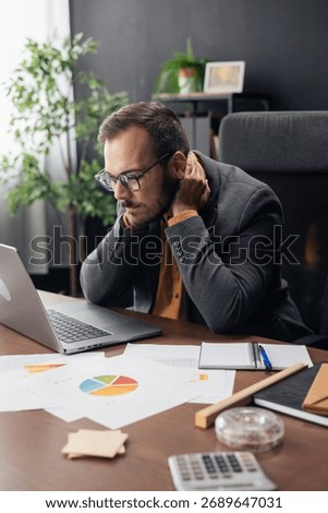 Man experiencing neck pain while working long hours at a corporate office desk