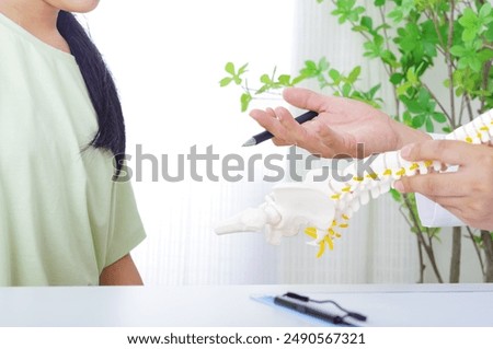 A man explaining in a skeleton model and a woman in a patient