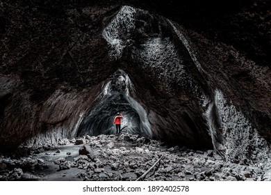A man exploring a cave with a flashlight