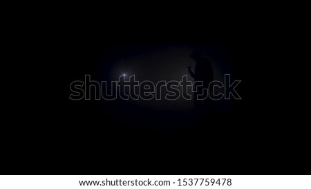 Man exploring huge underground cave with dim torch, adventure and travel concept. Stock footage. Dangerous, scary complete darkness inside the cave, black and white.