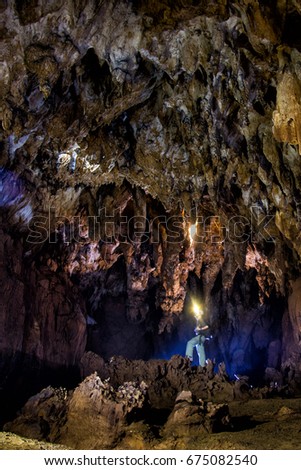 Man exploring huge underground cave .dark majestic landscape