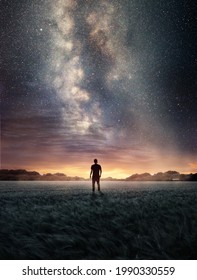 A man Exploring the night sky as the Milky Way galaxy fills the landscape from above. Photo composite - Shutterstock ID 1990330559