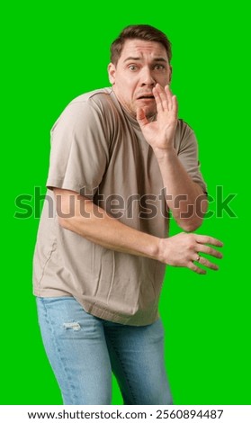 Man expressing fear while standing against a bright green background