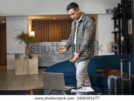 Man Expressing Frustration While Using Laptop in Modern Hotel Lobby Setting