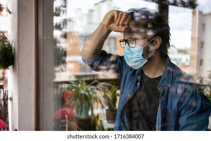 Man with face mask looking out of window
 - Powered by Shutterstock