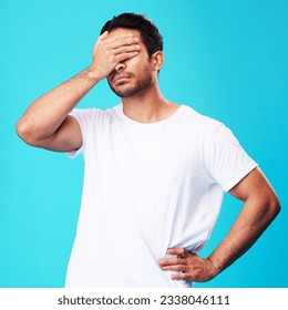 Man, face palm and mistake in studio with thinking, regret and anxiety for fail by blue background. Young guy, student and cover eyes with stress, memory and shame for bad decision with depression - Powered by Shutterstock