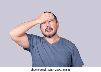 A man face palms, slapping his forehead in frustration. Feeling embarrassed or dismayed. - Shutterstock ID 2200735635