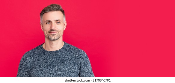 Man Face Portrait, Banner With Copy Space. Hair And Skin Care. Smiling Grizzled Guy In Sweater On Red Background. Hoary Man Portrait.